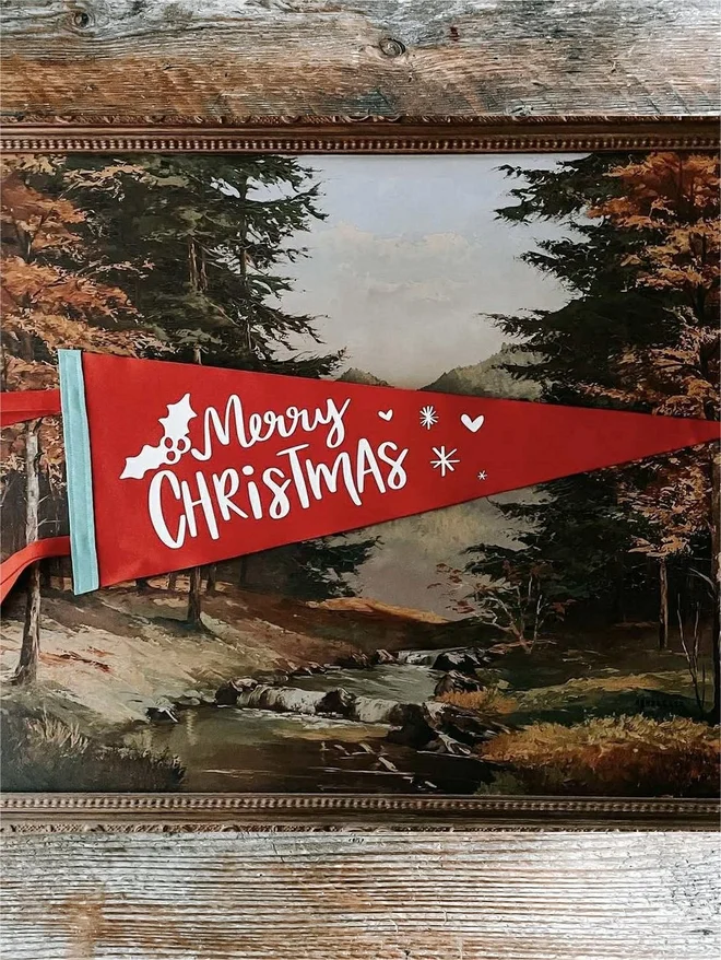 a red and white felt pennant flag with the words Merry Christmas printed on it