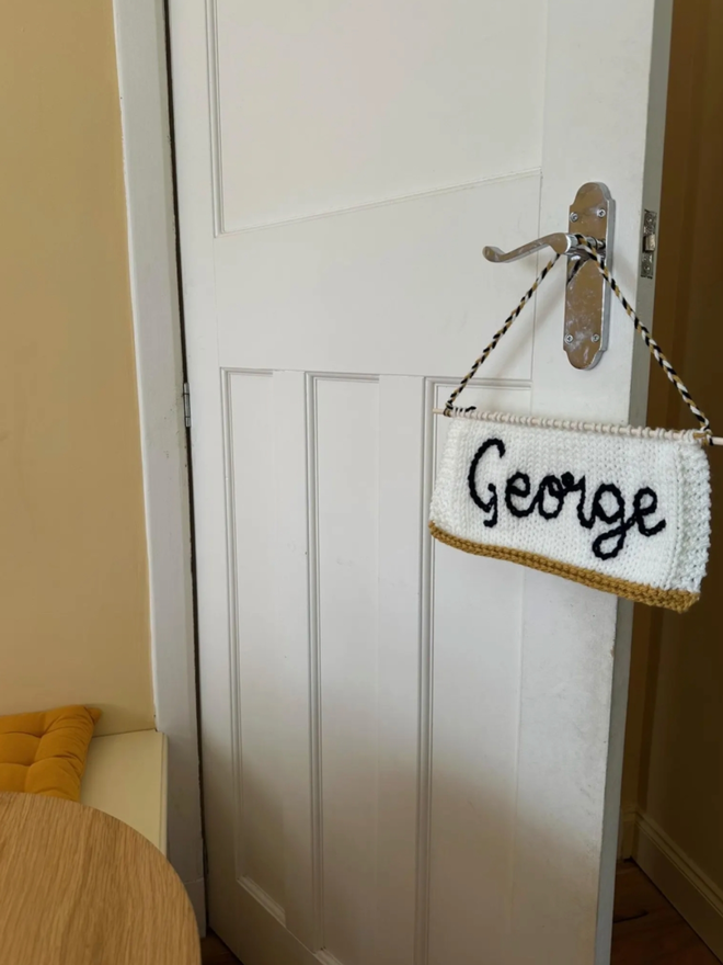 Calligraphy Banner. A calligraphy banner in white hanging from a doorknob.