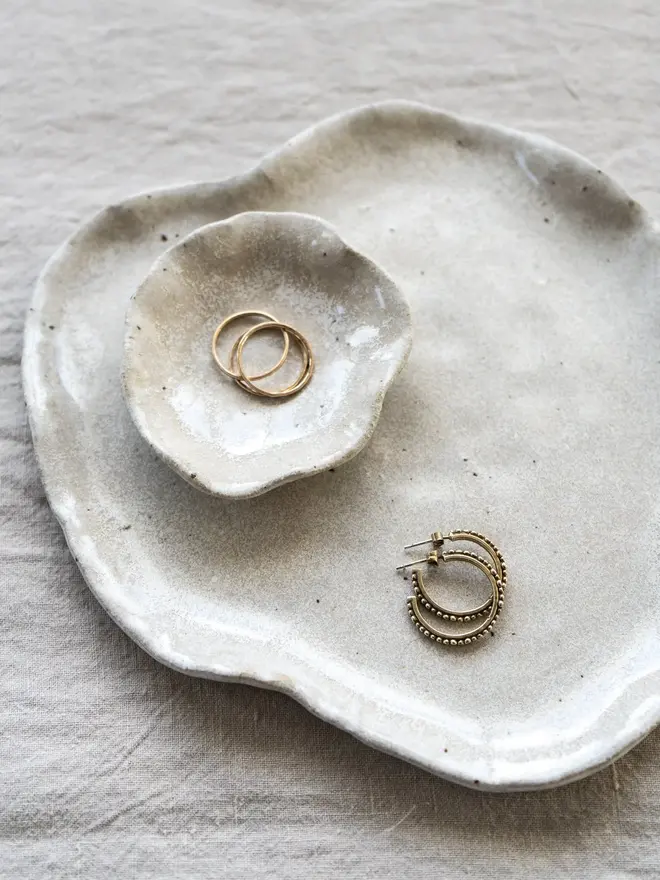 Lily Pad Jewellery Dish In Sea Salt Glaze, dishes stacked on top of each other with rings in them, on a table cloth. 