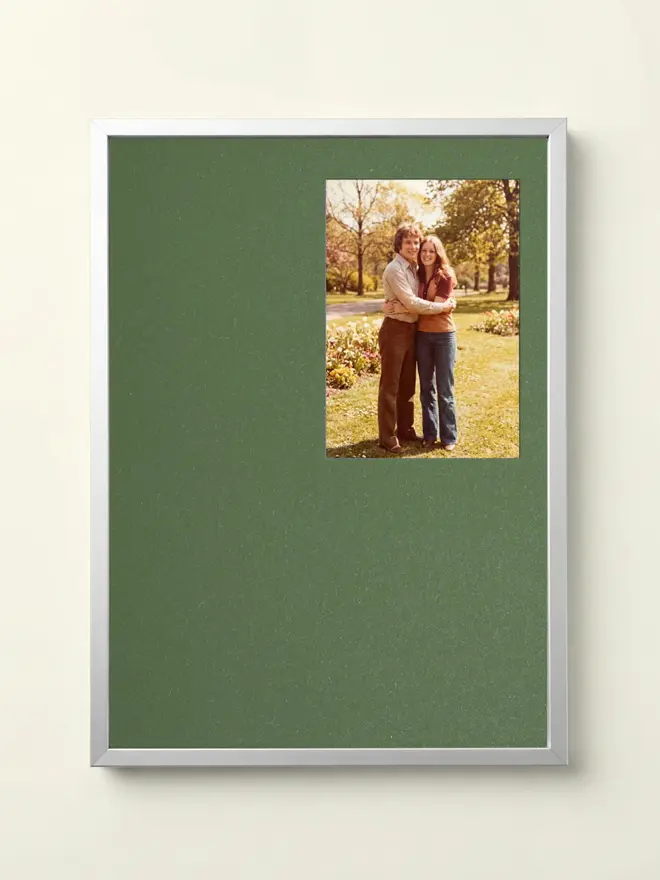 Mid Green Mounted Silver Picture Frame, hanging on a white wall. 