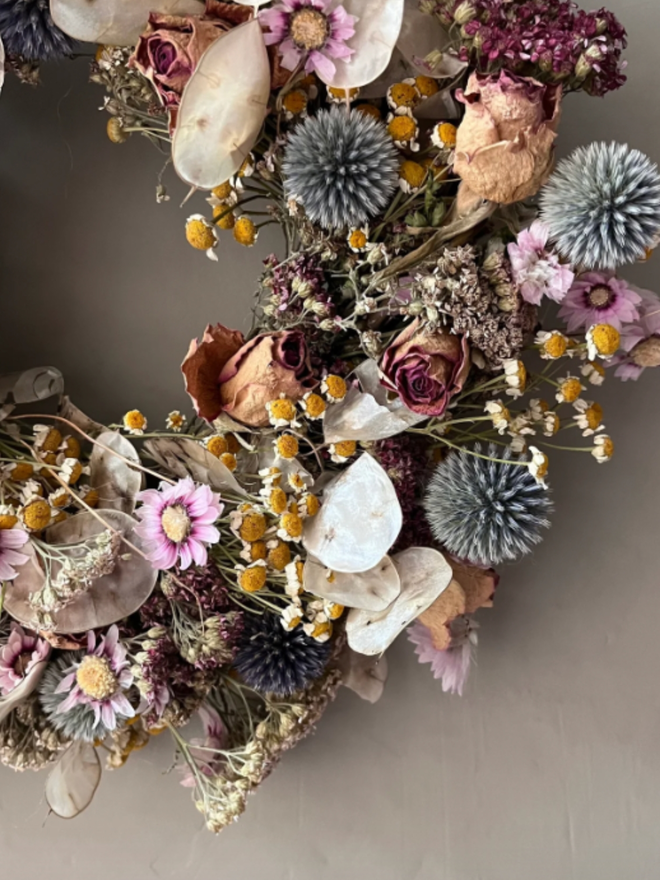 Autumnal Dried Flower Wreath. A wreath made of seasonal autumnal flowers, hung on a wall.
