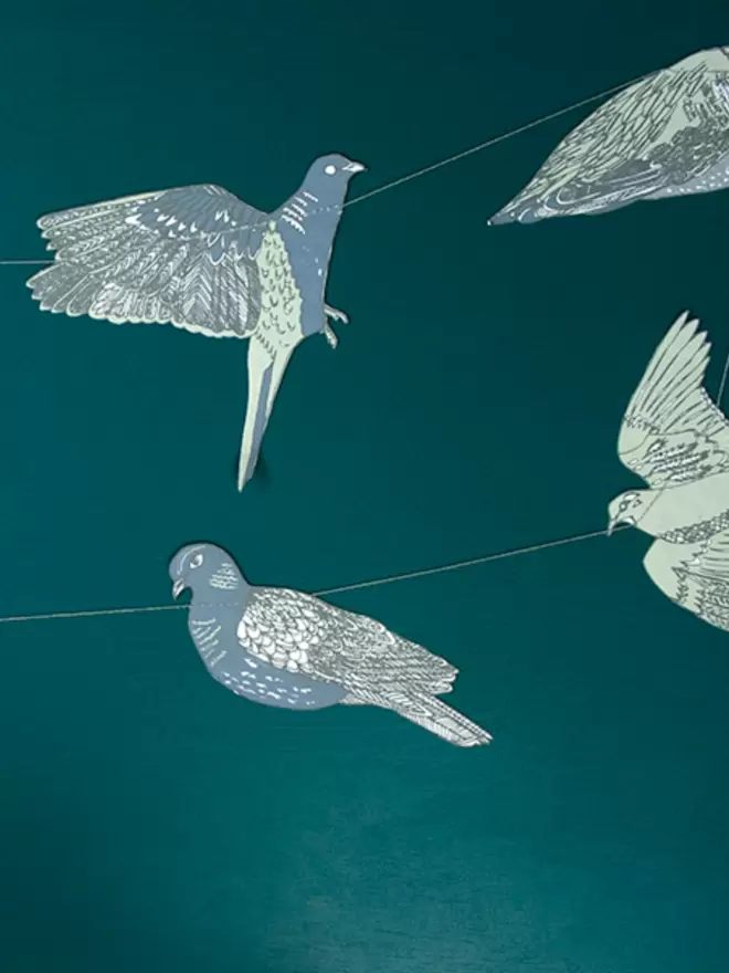 Close up of blue and grey doves decorations on a deep green background