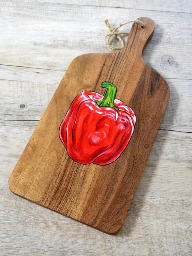 Wooden serving board with handpainted red pepper design