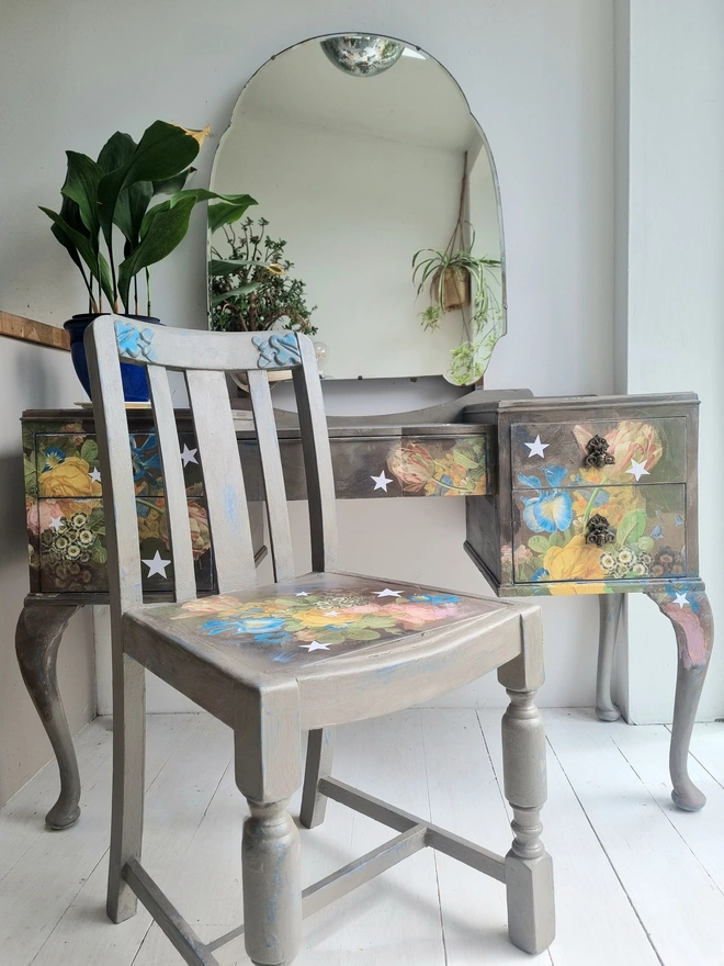 Vintage painted dressing table and chair. Painted in coffee grey and decorated using layered antique florals with yellow and blue accents and finished with hand-cut white paper stars. Text reads in blue 'think happy thoughts'. Heavily distressed finish.