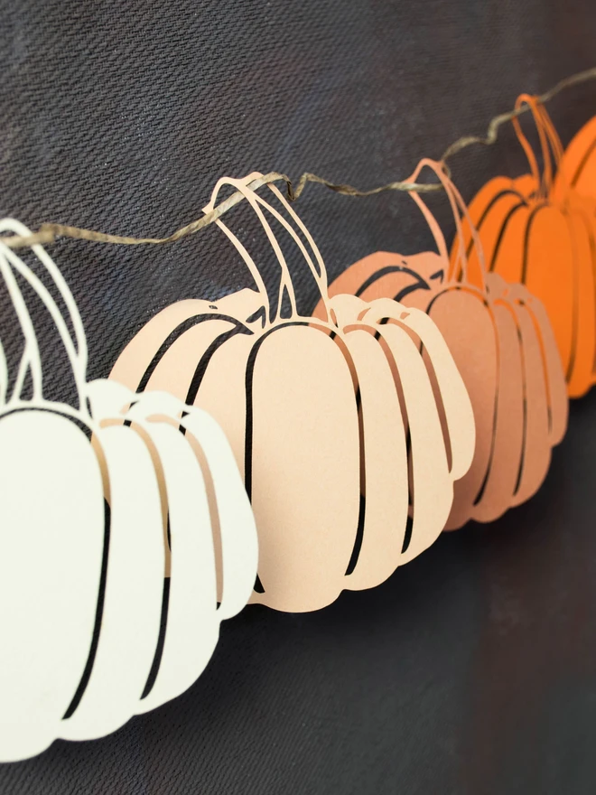 Closeup of ombre mix paper pumpkin decorations. From lft to right, cream, honey, cinnamon, orange colours.