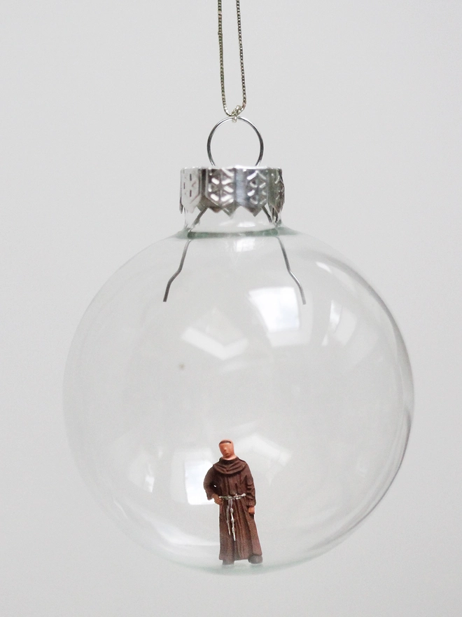miniature monk figure in a glass christmas bauble