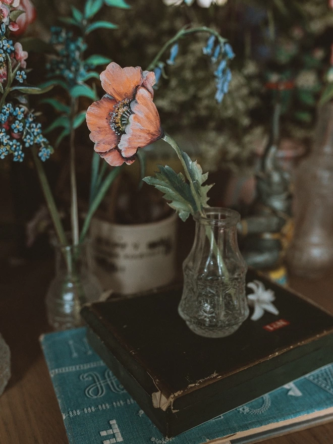 Wooden Poppy Stem in a vase, set amongst some fresh flowers