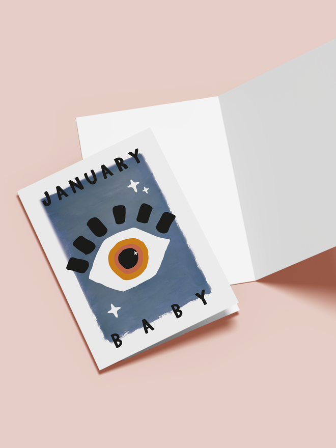 'january baby' illustrated card. a blue card with an illustrated eye in the centre.