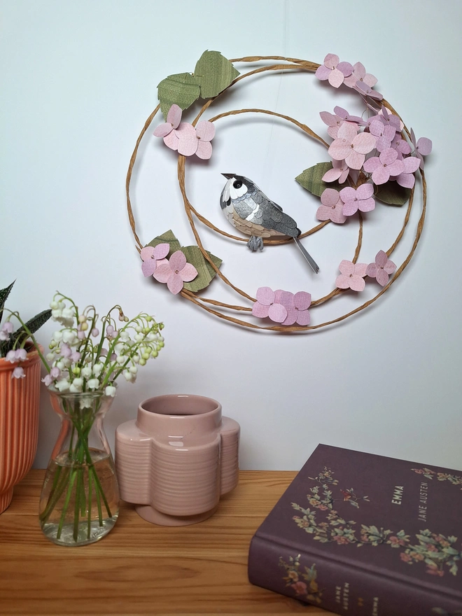 Handmade wall art featuring a coal tit bird sculpture perched on a floral wreath