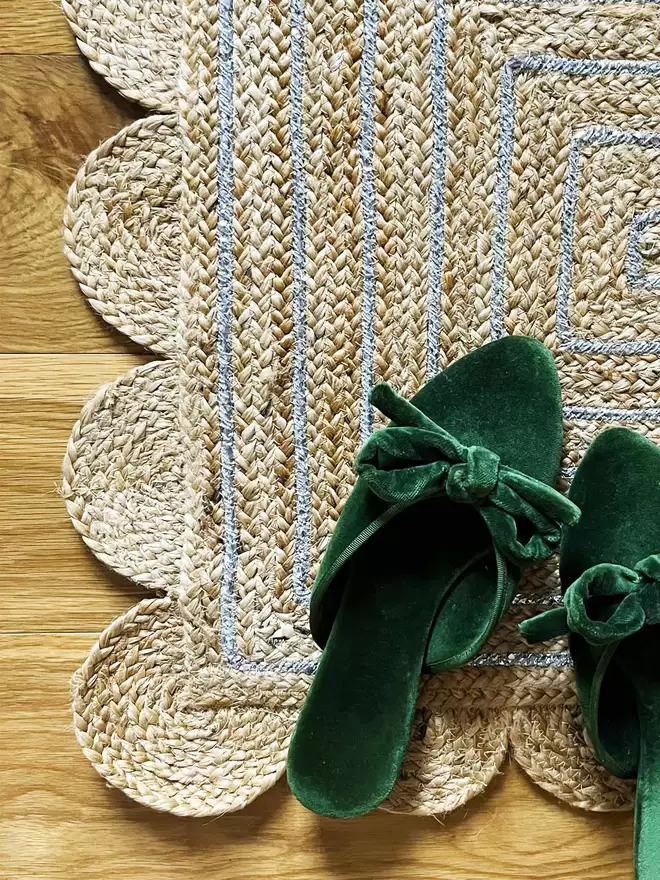 Detail of scallop edge mat with a pair of dark green velvet slippers on top