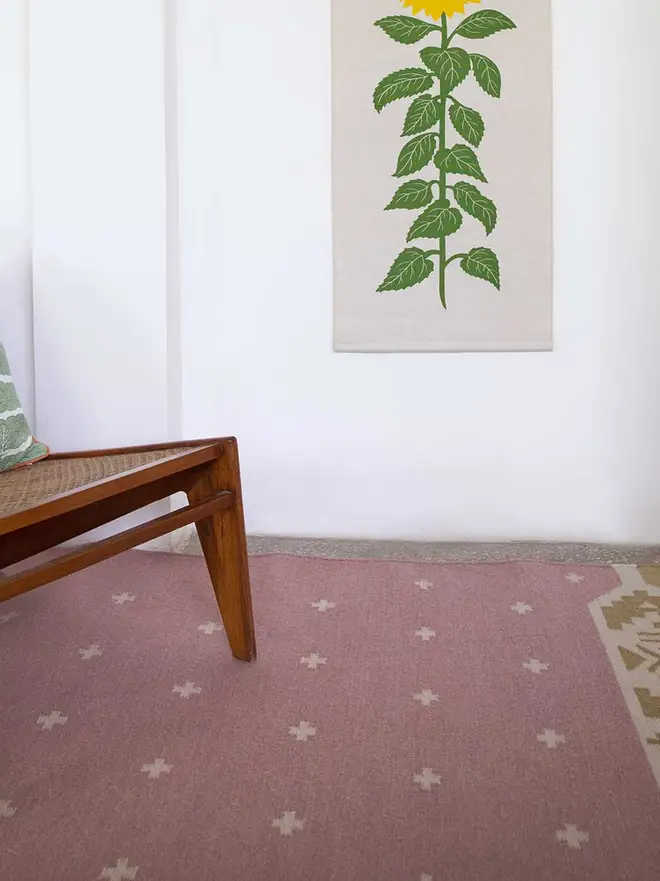 Manali Flatweave Rug, a colourful rug sitting in a bedroom. It is accompanied by other colourful furniture. 