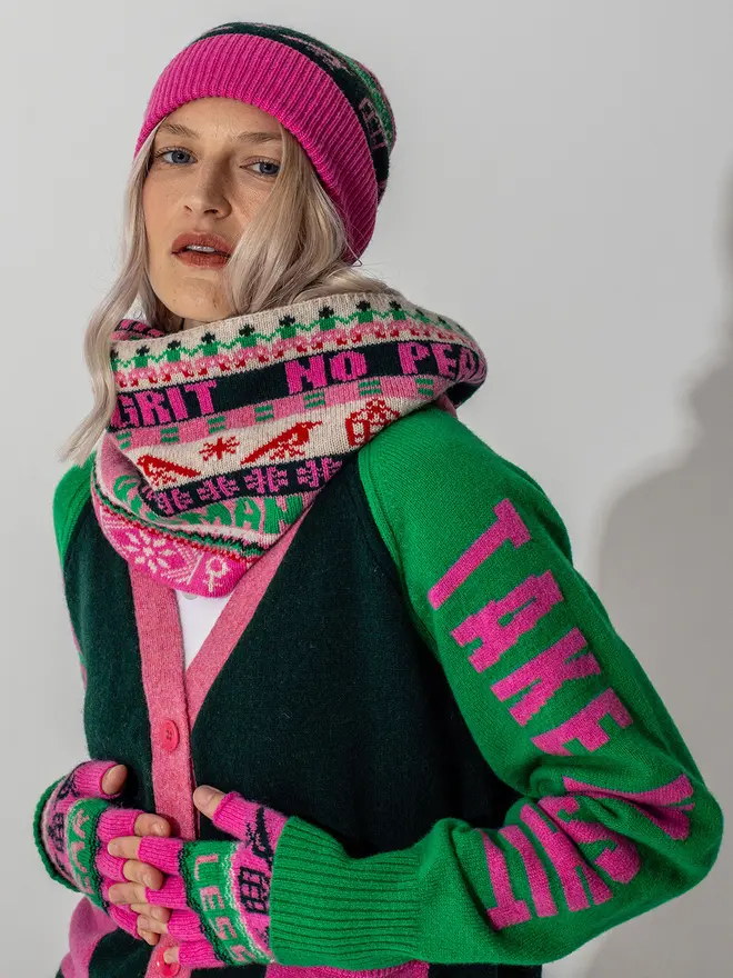 Model is wearing our fairisle beanie with our loop scarf, fearless mittens and Do No Harm Cardigan in Kelly green and bubblegum 