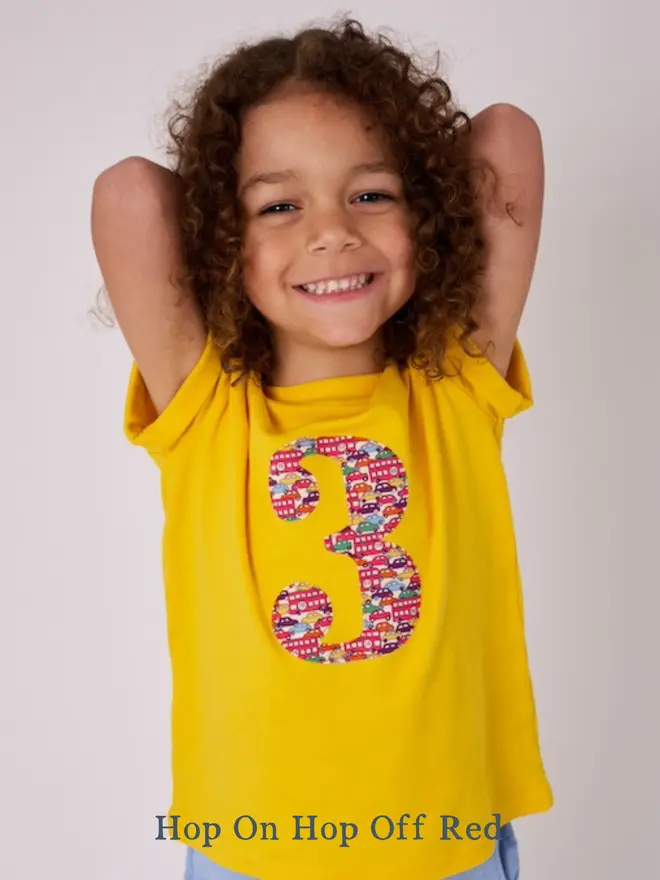 a 3 year old birthday boy wearing a yellow t-shirt with a Liberty car print number 3 on front