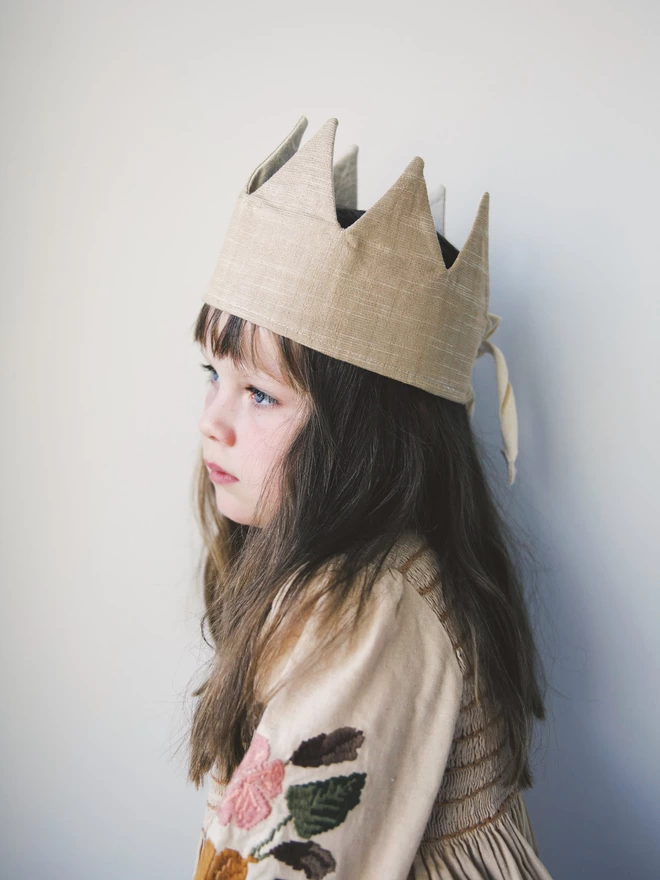 Girl with long brown hair wearing the old gold linen fancy dress crown