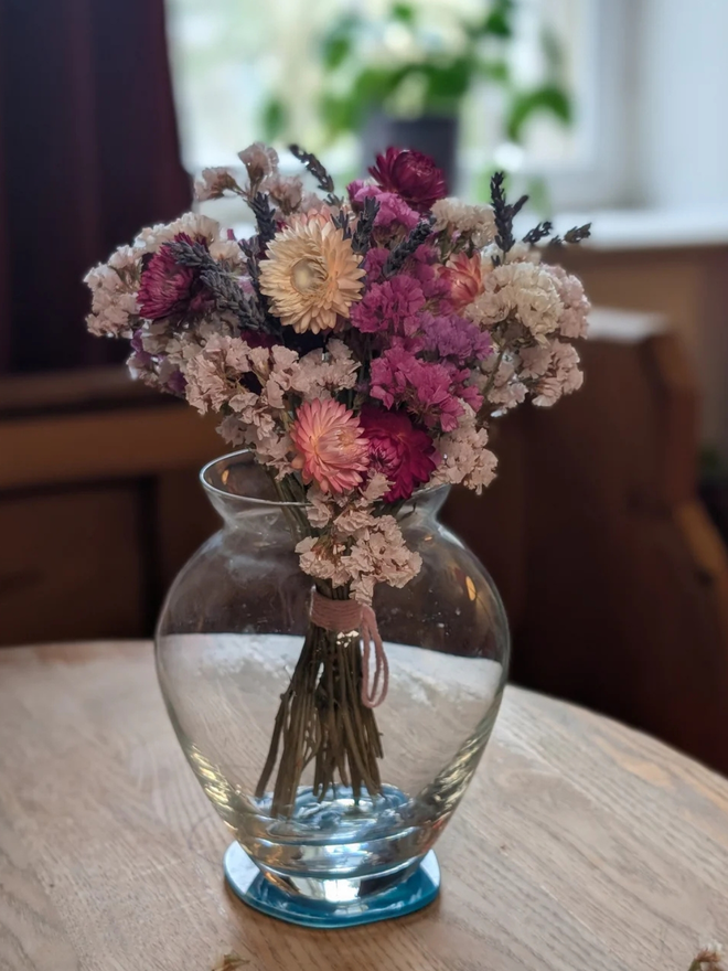 dried flower kit. pink, white and purple dried flower kit assembled into bouquet and placed in glass vase.