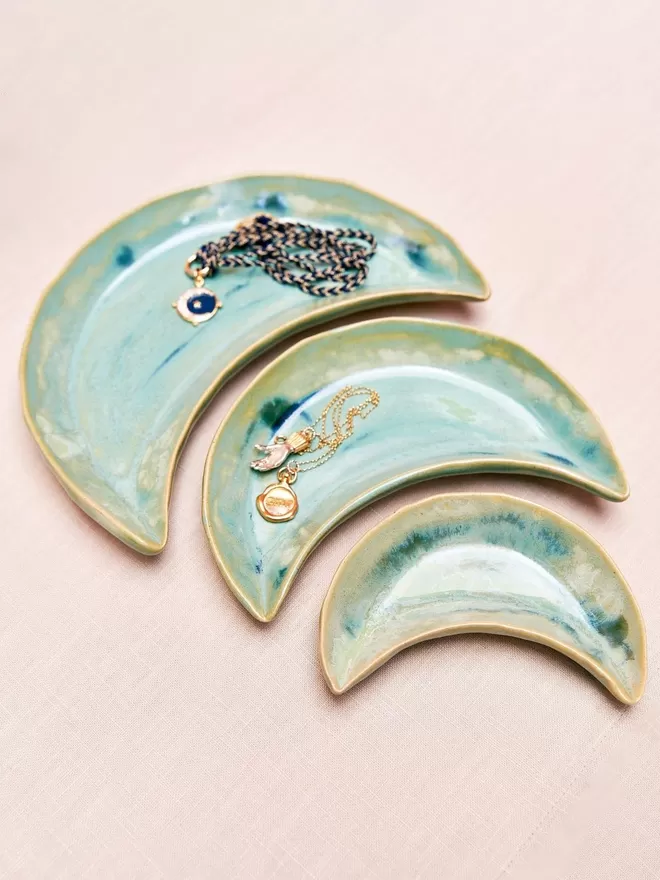 Moon Trinket Dish, Jewellery Dish, Jewellery Holder, Jewellery Storage, Jenny Hopps Pottery, J.H Pottery, J.Hopps Pottery, Ceramics, Homeware, Pottery, Gifts, Gift, Gift for her, Pink, Cream, White, Photographed against a mottled grey background with flowers,AQUA TURQUOISE , multiple moon dishes