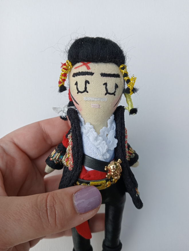 1980s Adam Ant mini decorative icon doll held in a left hand for scale against a white background 
