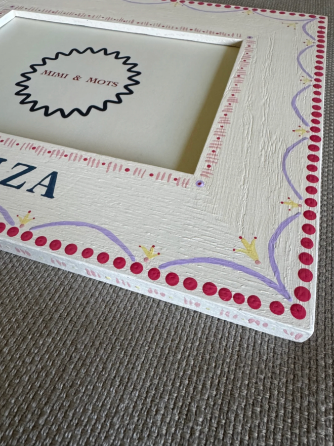 Girls’ Personalised Hand Painted White Photo Frame. A photo frame with intricate pink, white, purple and yellow designs.