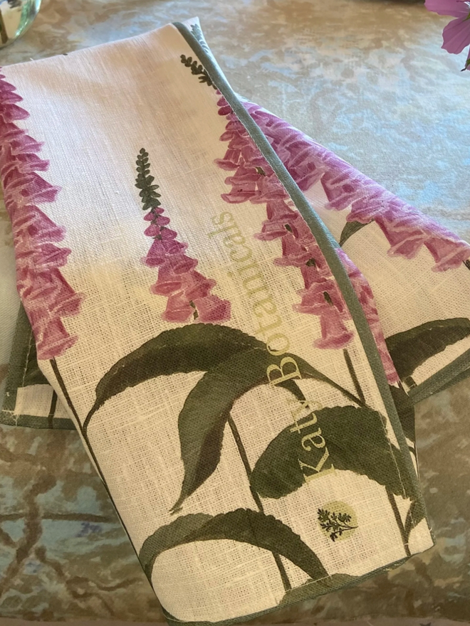 Foxglove Tea Towel. A white tea towel patterned with purple fox gloves.