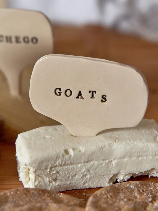 Ceramic Cheese marker that reads Goats placed in a goats cheese 