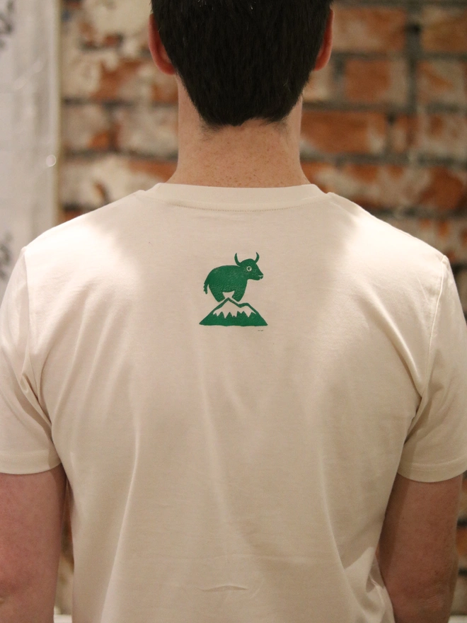 Man wearing a t-shirt and hat, a Yak linocut image printed on the white tshirt