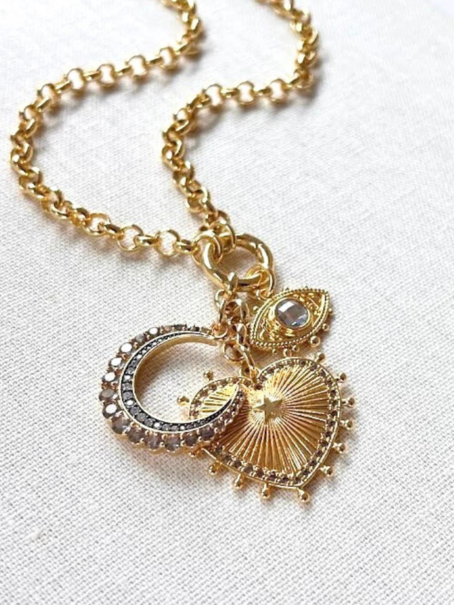 Gold sunburst heart necklace with grey stone crescent moon charm