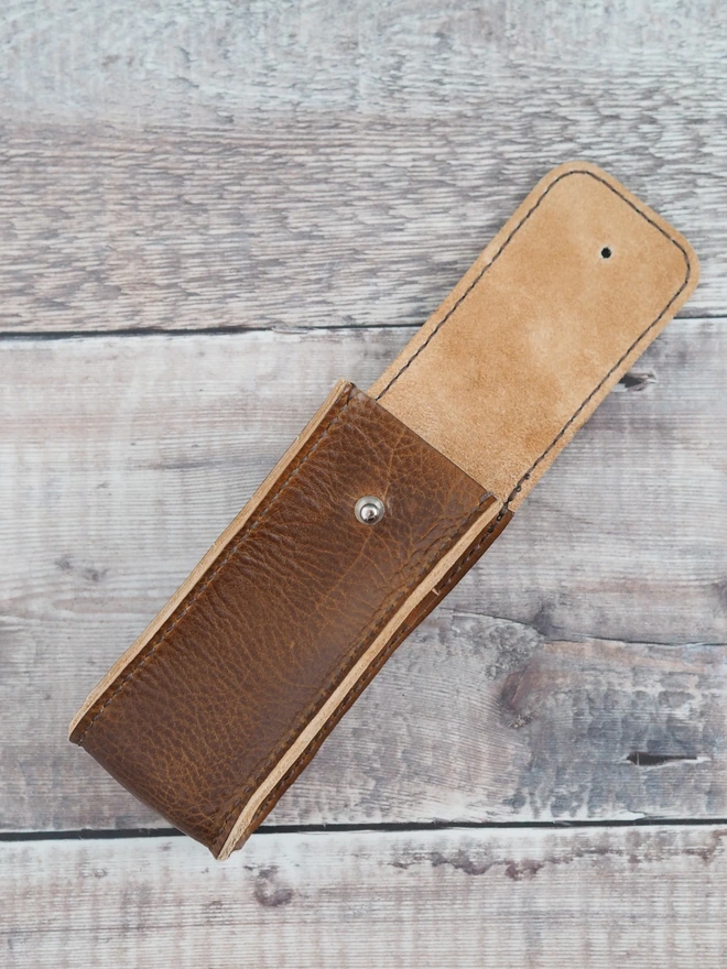 Handmade leather golf ball and golfing tee holder. The back of the case features a swivel clip to attach to a gold bag.