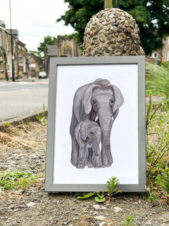 a print featuring an illustration of a mother elephant with her calf