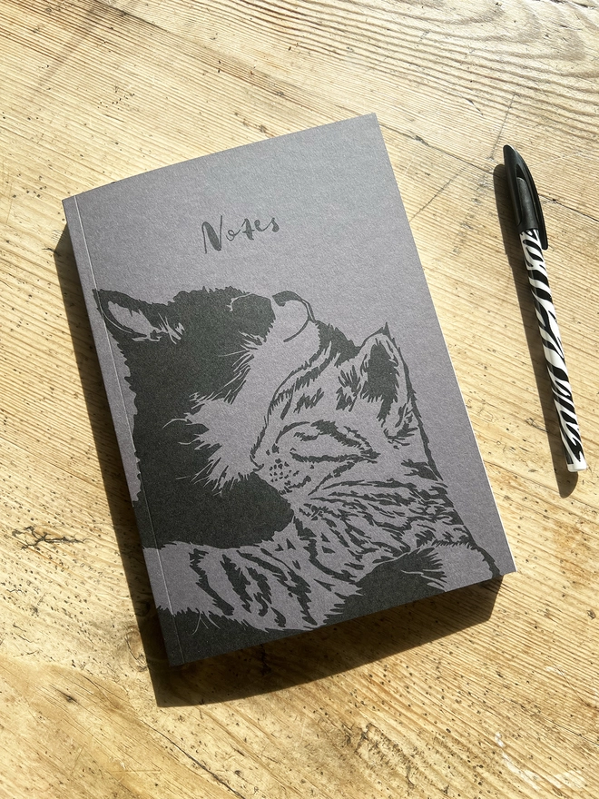 Front of the notebook showing Two cats cuddling.