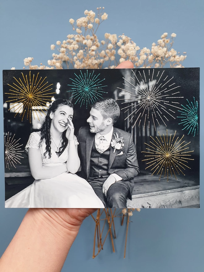  Wedding photo in B&W with hand embroidered sparkly fireworks held against blue background