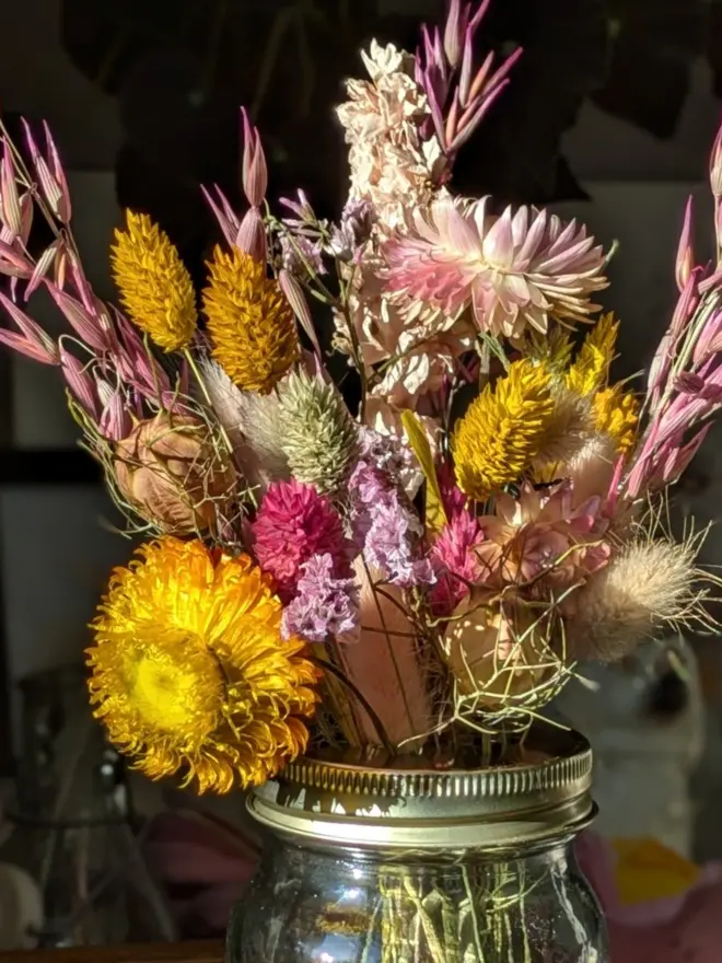 Dried flowers in mason jar with daisy lid