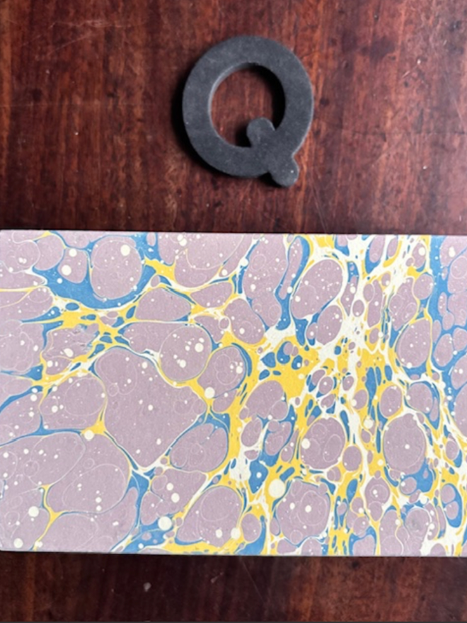 Matchbox Cover. A matchbox cover in Q