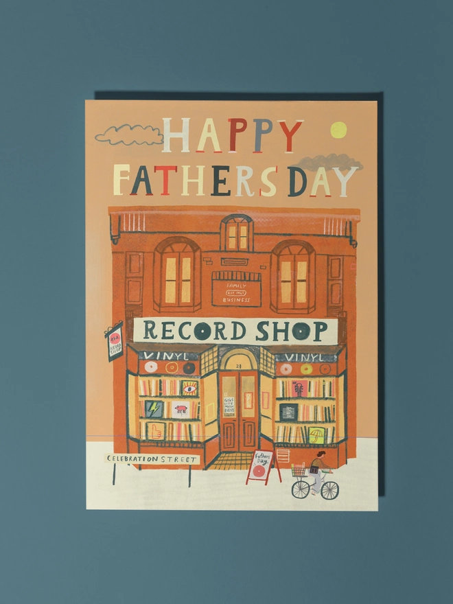 record shop illustrated fathers day card. illustrated red brick record shop building with 'happy fathers day' on orange background.