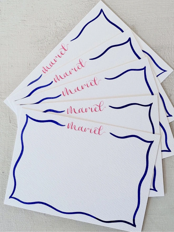 Personalised notecards with the name in bright pink and the wavy border in dark blue