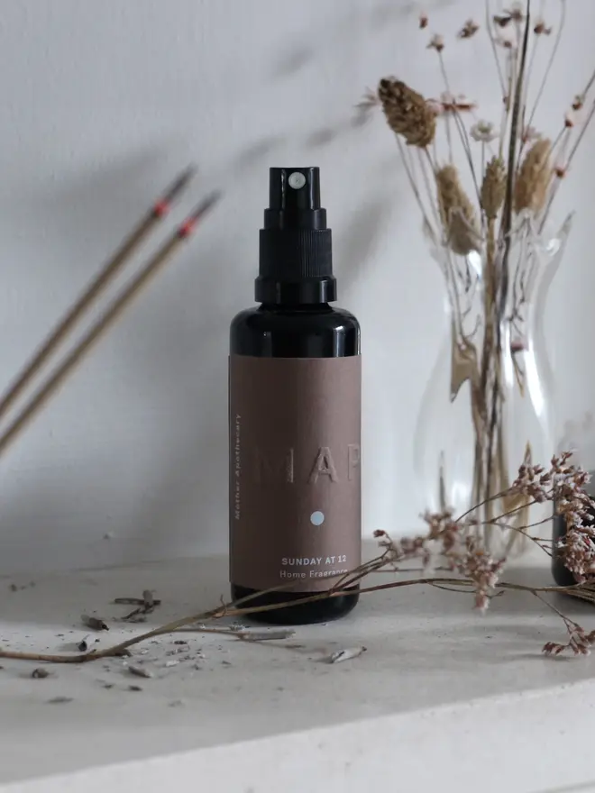 sunday at 12 sandalwood and rose home fragrance spray. bottle photographed on shelf with dried flowers.