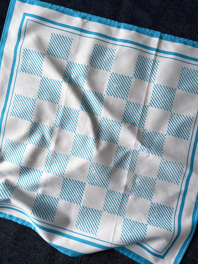 A Mr.PS Draughts Checkerboard printed cotton napkin laid on a tablecloth