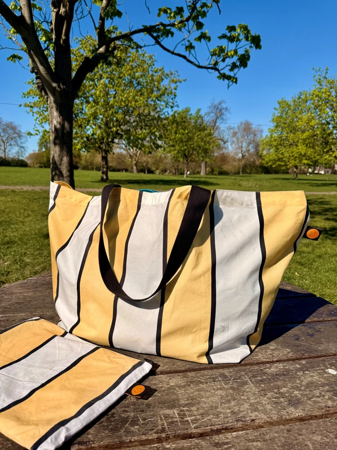 yellow and white stripes bag on picnic table in a park