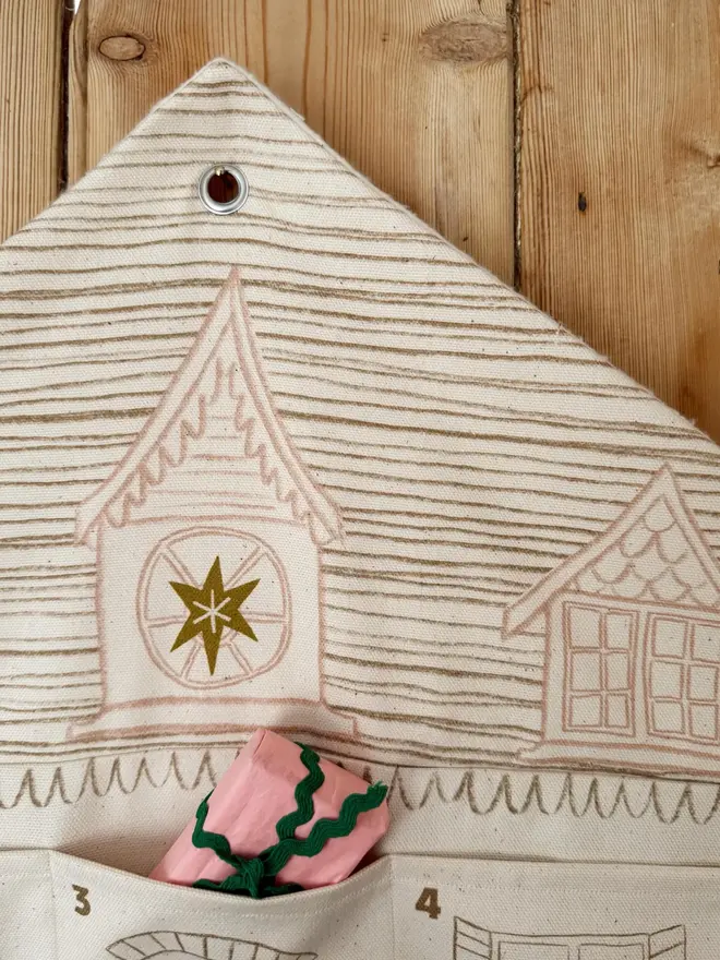 Fabric Christmas House Advent Calendar, hanging on a door. 