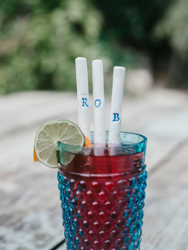 Monogram straws seen in a cup of juice.