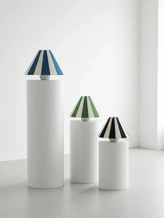 Hand Painted Upcycled Striped Large Drum Lampshade, a group of striped lampshades sitting on white pillars against a white background. 