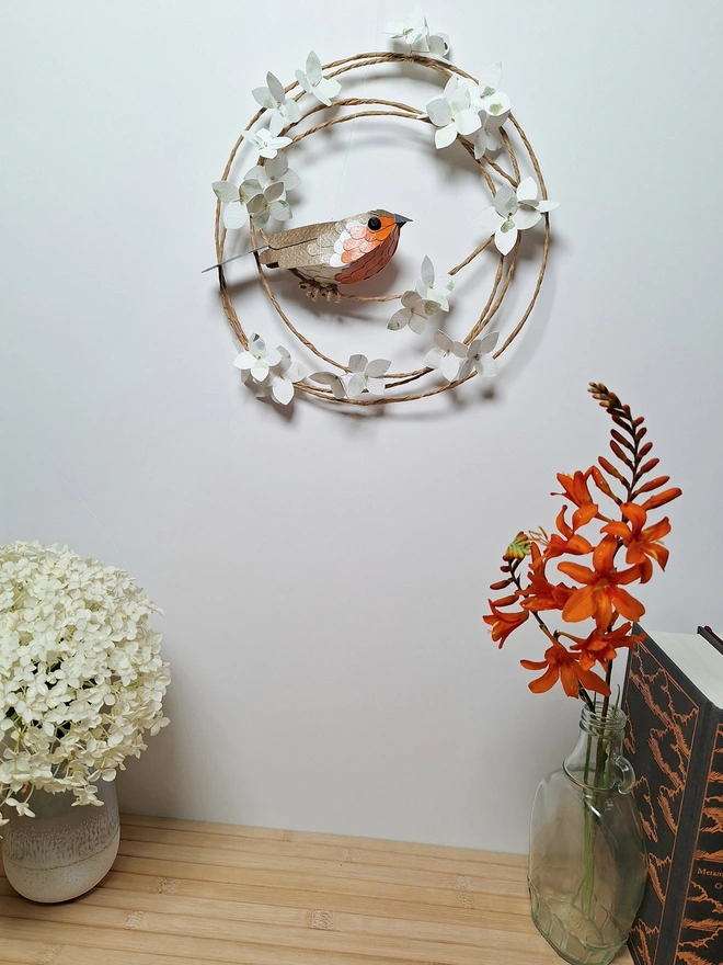 floral wall art featuring a handmade paper robin sculpture