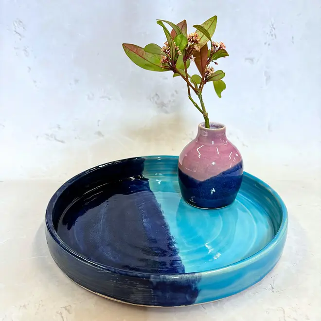 Landscape Tray, a colourful tray sitting on a stone surface. It is accompanied by a vase with a plant in it. 