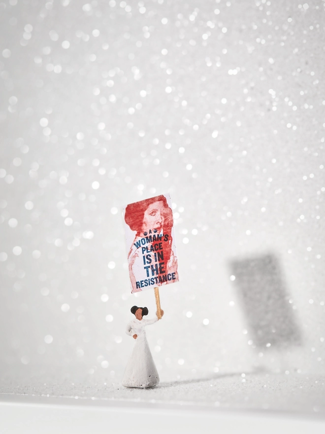 Miniature scene in an artbox showing a tiny Princess Leia figurine holding a protest banner