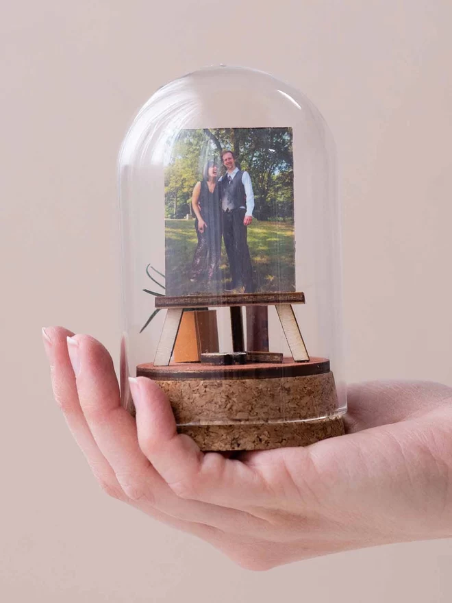 a family portrait on a glass dome on top of a hand