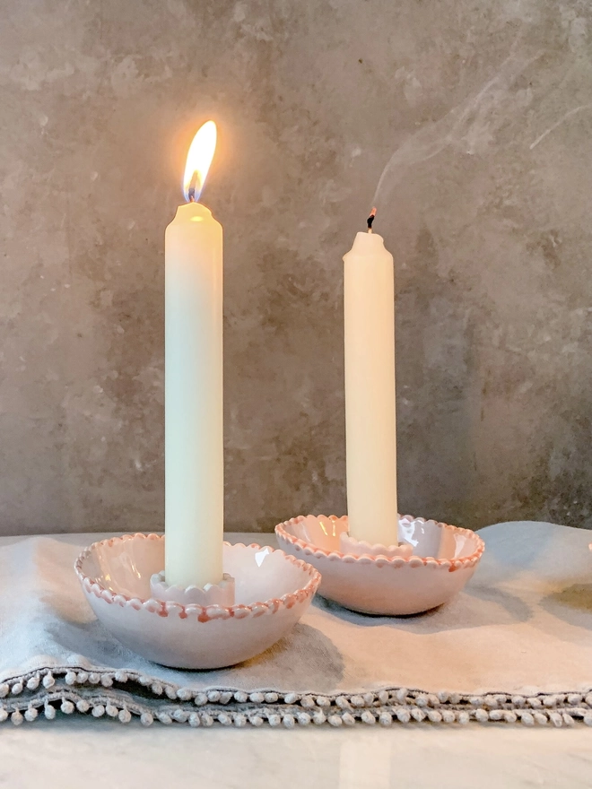 a pair of low candlestick holders with candles