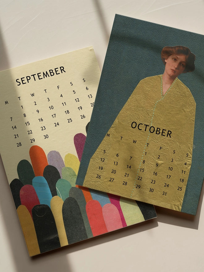 Two pages of a desk calendar sitting on a sunlit desk.