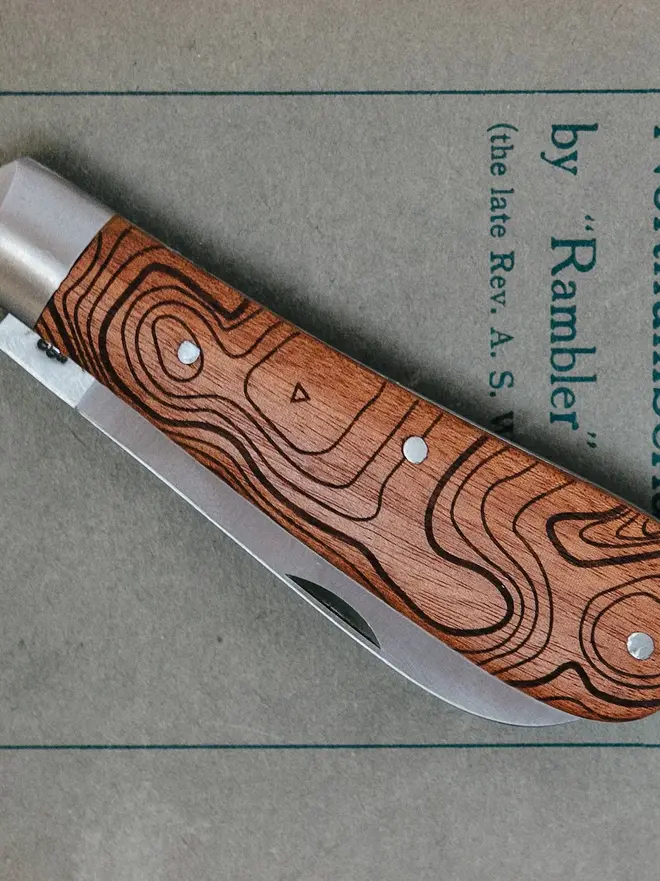 'the cheviot' folding pocket knife. a steel pocket knife with a brown wooden handle, folded up.