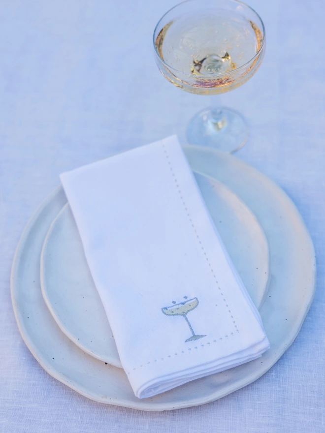 Embroidered white champagne glass napkin