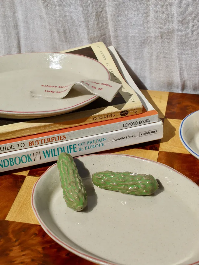 Still Life Trinket, a collection of trinkets sitting on a plate on a wooden surface.  Dish
