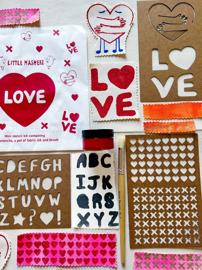 Image of different non plastic love stencils with fabric paint and brush